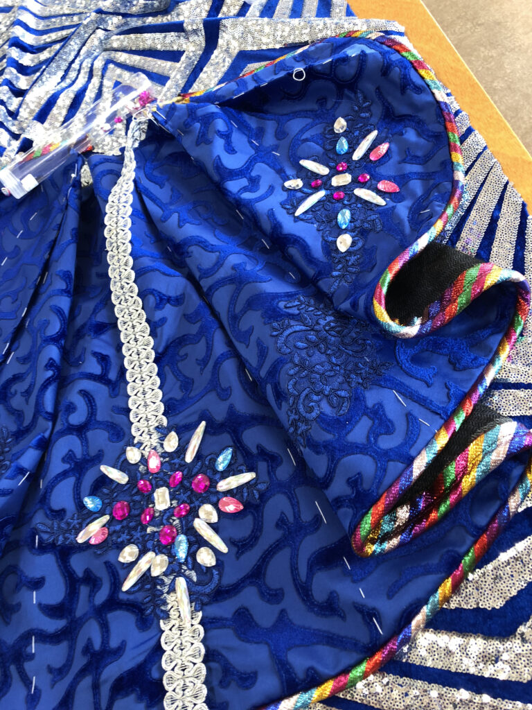 detail ontwikkeling carnavalsjas in blauw roze stenen glitters