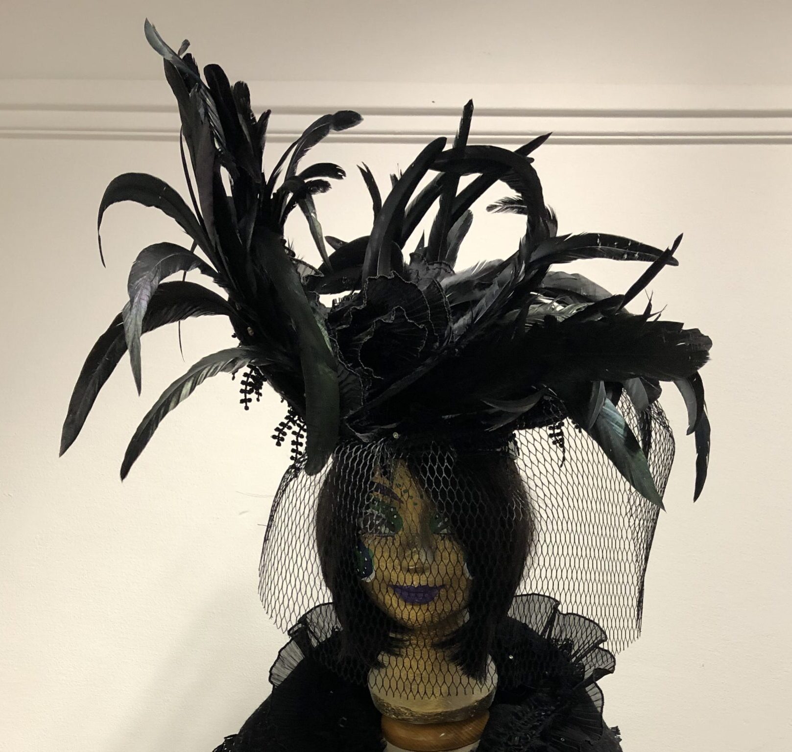 zwarte hoed met veren lampjes en voile